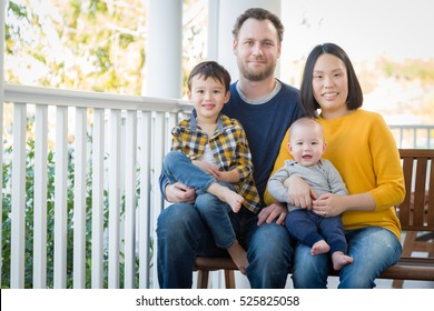 Young Mixed Race Chinese And Caucasian Family Portrait On Their Front Porch.