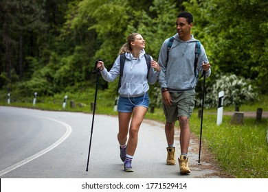 Young Mixed Race Couple Hiking In Nature.They Walking By The Old Country Road.