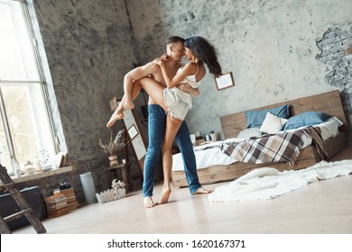 Young Mixed Race Couple Man Holding Woman's Hip Dancing In Bedroom At Home Laughing Cheerful Faces Close Sensual Closed Eyes Delightful