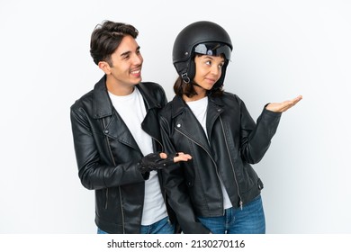 Young Mixed Race Couple With A Motorcycle Helmet Isolated On White Background Pointing Back And Presenting A Product