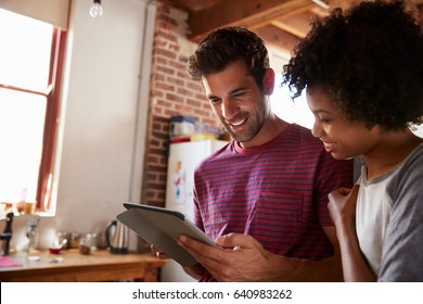 Young mixed race couple using tablet in kitchen, close up - Powered by Shutterstock