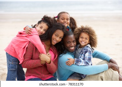 Young Mixed Race Family Embracing On Beach