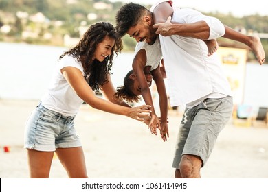 Young Mixed Race Family Hangout Outdoors And Making Fun On Beautiful Summer Day.