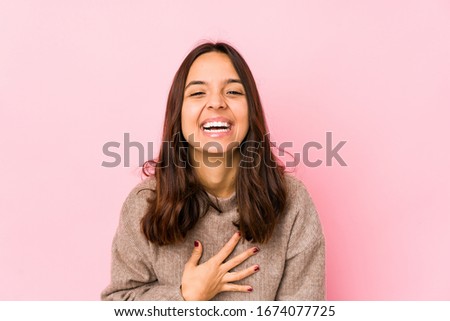 Young mixed race hispanic woman isolated laughs out loudly keeping hand on chest.
