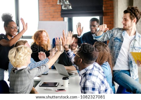 young mixed race people comparing their hands indoors
