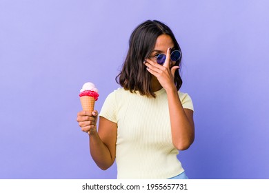 Young Mixed Race Woman Eating An Ice Cream Blink At The Camera Through Fingers, Embarrassed Covering Face.