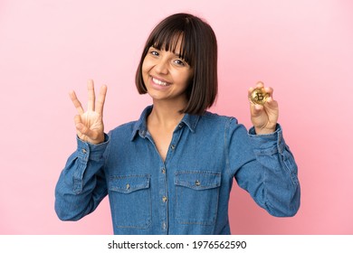 Young Mixed Race Woman Holding A Bitcoin Isolated Background Happy And Counting Three With Fingers