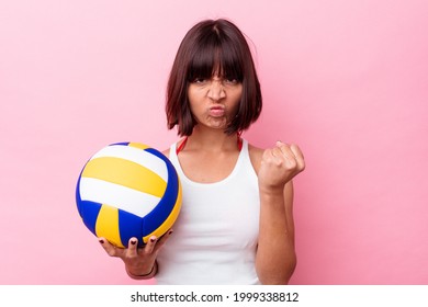 Young Mixed Race Woman Playing Volleyball Isolated On Pink Background Showing Fist To Camera, Aggressive Facial Expression.