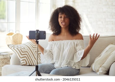 Young Mixed-race Blogger Streaming Online In A Social Network And Communicates With Her Subscribers, Recording Video Vlog Podcast On Smart Phone Sitting At Home, Chatting On A Video Call