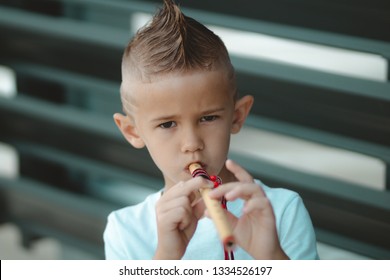 Young Model Boy With Mohawk Playing The Native American Flute