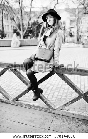 Similar – Junge Frau sitzt auf einer Bank in einem Park in ruhiger Pose.