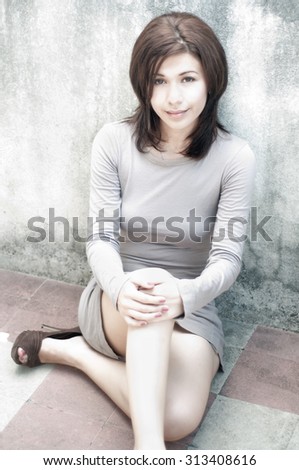 A young model sitting down posing in a sexy fashion 