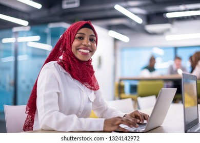 Young Modern Black Muslim Business Woman Wearing A Red Hijab,working On Laptop Computer In Startup Office. Diversity, Multiracial Concept