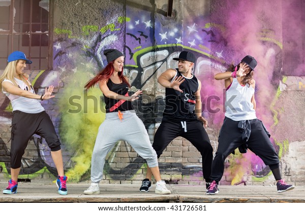 Young modern dancing group practice dancing  in\
front colorful wall