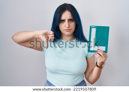 Young modern girl with blue hair holding l sign for new driver with angry face, negative sign showing dislike with thumbs down, rejection concept  Photo stock © 