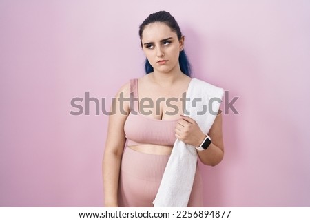 Young modern girl with blue hair wearing sportswear over pink background looking sleepy and tired, exhausted for fatigue and hangover, lazy eyes in the morning. 