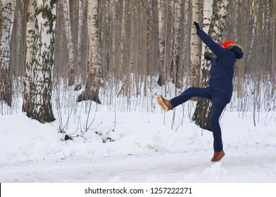 Young Modern Man Slipped And Lost His Balance During A Walk On A Birch Grove In Winter. Freeze Frame While Jumping And Waving His Hands Before Falling To The Snow.