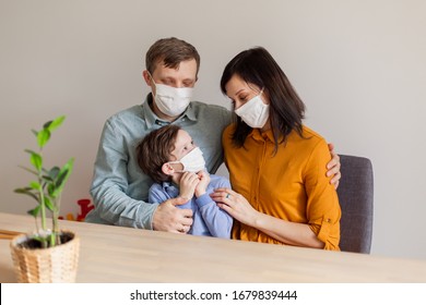 Young Modern Quarantined Coronavirus Family In Medical Masks. The Call To Stay Home Stop The Pandemic. Self-isolation Together Is The Solution. Care Covid-19. Mom Dad Son Millennials