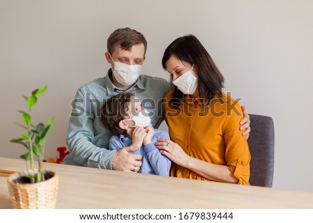 Young modern quarantined coronavirus family in medical masks. The call to stay home stop the pandemic. Self-isolation together is the solution. Care covid-19. mom dad son millennials