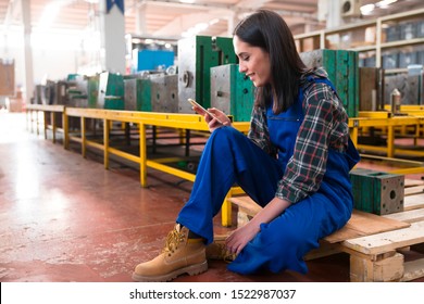 Young modern woman using touch screen mobile phone in warehouse storage. - Powered by Shutterstock