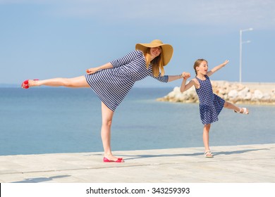 Young Mom And Her Daughter On The Dock Being Silly