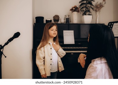 Young mom and little preschooler daughter at home learn sign language together, female nanny or teacher talk nonverbal with small disabled kid, practice sounds and signs making gestures - Powered by Shutterstock