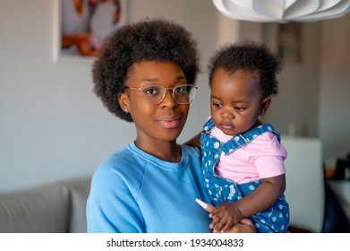 A Young Mom Posing At Camera With Her Baby