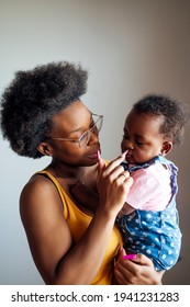 A Young Mom Posing At Camera With Her Baby