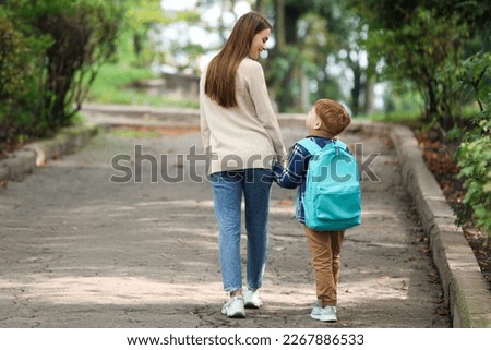 Young mom taking her son to school