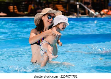 Young Mom And Toddler Child Girl Swimming And Smiling In Summer Warm Pool Water, Happy Family Vacation