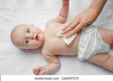 Young Mom Wiping The Baby Skin Body And Face With Wet Wipes Carefully On White Background. Concept Cleaning Wipe, Pure, Clean.