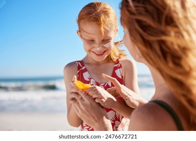 Young mother applying protective sunscreen on daughter nose at beach with copy space. Woman hand putting sun lotion on female child face at sea. Cute little girl with freckles applying sunblock cream. - Powered by Shutterstock