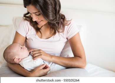 Young mother with baby in bed - Shutterstock ID 550105264