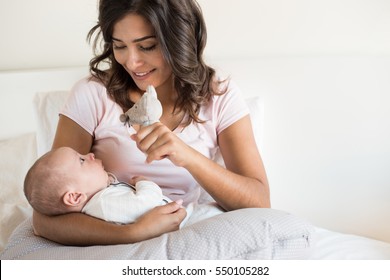 Young Mother With Baby In Bed