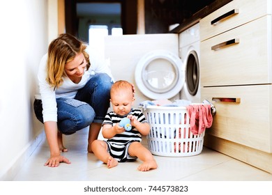 Young Mother With A Baby Boy Doing Housework.