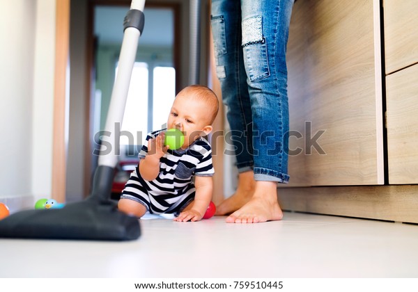 Young mother with a baby boy doing housework.