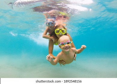 Young mother, baby boy, girl jump, dive underwater with fun in tropical lagoon pool. Travel lifestyle, water sport, snorkeling adventure. Family swimming lesson on summer sea beach vacation with kids