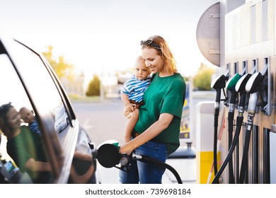 Young mother with baby boy at the petrol station.