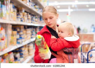 Young Mother With Baby Daughter Shopping In Supermarket