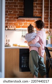 Young Mother With Baby Girl On Her Hands Cooking Together At Kitchen At Home, Domestic Chores At Maternity Leave.