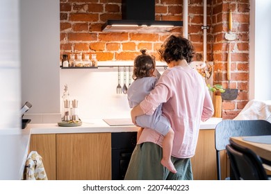 Young Mother With Baby Girl On Her Hands Cooking Together At Kitchen At Home, Domestic Chores At Maternity Leave.