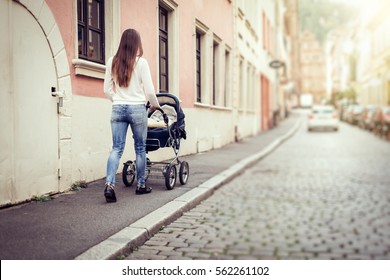 Young Mother With Baby Stroller In The City
