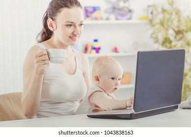 Young Mother And Baby Using Laptop To Communicate With Grandma Via Skype,