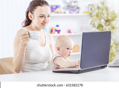 Young Mother And Baby Using Laptop To Communicate With Grandma Via Skype,