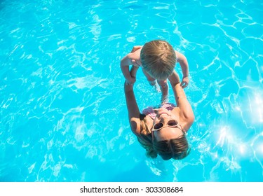 Young Mother Bathing In The Pool With Your Child
