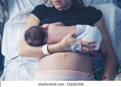 A young mother is breastfeeding her newborn child in the hospital