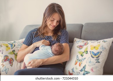 Young mother breastfeeding  her newborn baby boy at home