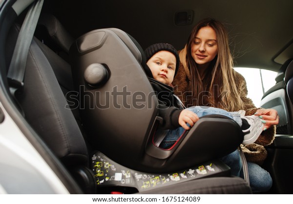 Young mother and child in car. Baby seat on
chair. Safety driving
concept.