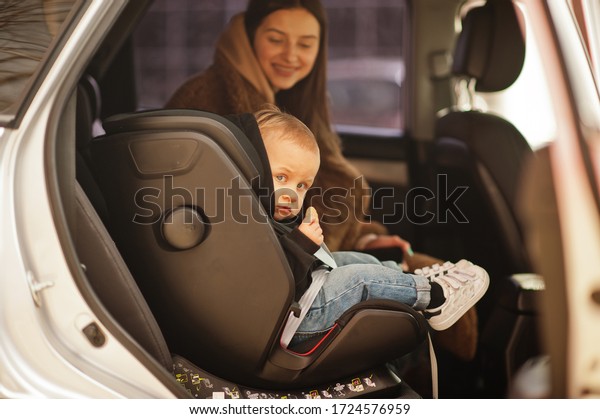 Young mother and child in car. Baby seat on\
chair. Safety driving\
concept.
