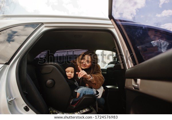 Young mother and child in car. Baby seat on\
chair. Safety driving\
concept.